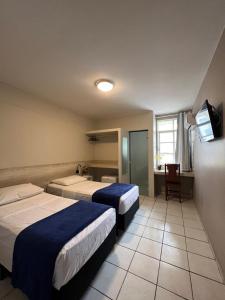 塔瓜汀加Europa Hotel Brasília的酒店客房设有两张床和电视。