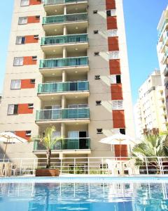 瓜鲁雅Apes Enseada Guarujá的大楼前设有游泳池的酒店