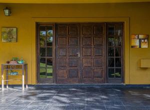 Las CompuertasCasona alegre con pileta y amplio jardin的黄色建筑的大木门