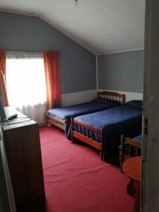 奥索尔诺Hostal Papo的一间卧室设有两张床、一个窗口和红色地毯