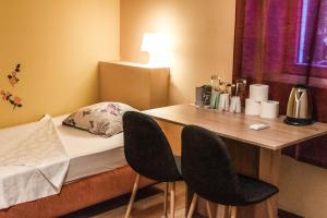 科佩尔Hostel Martin的小房间设有一张床和一张桌子及两把椅子