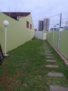 蒙加瓜Lindo Sobrado的绿墙旁的一条人行道,有草地