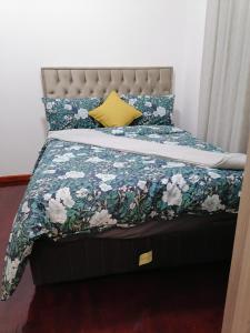 开普敦Lalibela gust house 2的一张带花卉棉被和黄色枕头的床