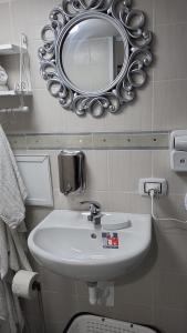 塔兰托the lighthouse accommodation的浴室设有水槽和墙上的镜子