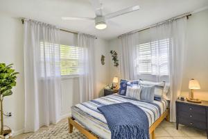 Merritt IslandMerritt Island Home Fire Pit and Canal Access!的一间卧室配有一张带蓝色枕头的床和一扇窗户。