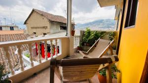 基多Hostal La Guayunga RoofTop的阳台配有椅子,享有房屋的景致。