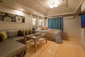 冈山ホテルウォーターゲート岡山的客房设有床、沙发和桌子。
