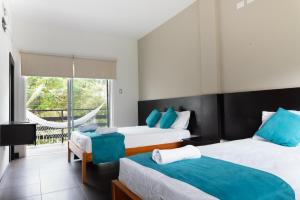 奥隆Ocean Blue Hotel的一间带两张床的卧室和一个阳台