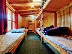 奈尼塔尔Mowgli Town Homestay/Resort的小木屋内设有一间带三张双层床的卧室