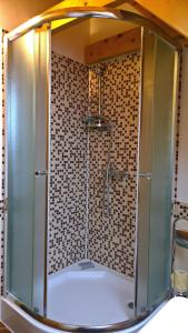 道尼库宾查鲁普卡纳奥拉维度假屋的浴室里设有玻璃门淋浴