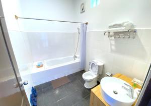格劳Hinode Hotel ဟိနောဒေ့ဟိုတယ်的浴室配有卫生间、浴缸和水槽。