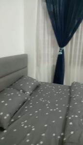 日得拉AZhomestay的一间卧室配有一张蓝色窗帘的床