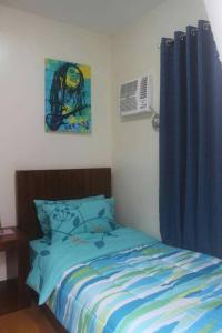 八打雁Pontefino Prime Townhouse 4BR with Wifi & Pool的一间卧室配有床和蓝色窗帘