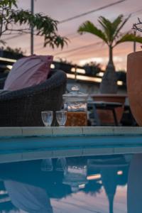 珀蒂蒂勒Le Coin d'Azur的游泳池配有2个玻璃杯和桌子