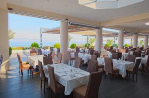 科斯镇齐普利提斯全景套房酒店 的一间设有白色桌椅的海洋餐厅