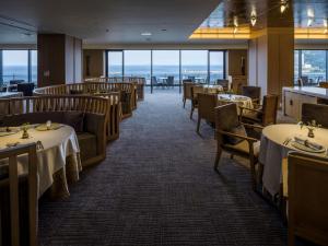 热海Pearl Star Hotel ATAMI的用餐室设有桌椅和窗户。