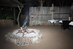 侯斯普瑞特Masodini Game Lodge的夜间院子中间的火坑