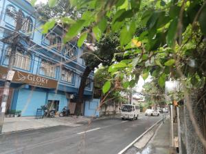 马尼拉Glory Hotel Cubao的一条城市街道,有蓝色的建筑和白色的货车