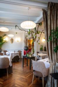 阿姆博斯洛奇酒店的一间设有桌椅和盆栽的餐厅