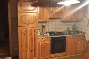 卡罗纳Appartamento piano terra in centro paese.的厨房配有木制橱柜、水槽和炉灶。