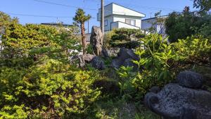 登别Showai的一座花园,在房子前面有岩石和植物