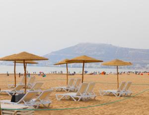 阿加迪尔阿加迪尔阿加纳酒店的海滩上的一组椅子和遮阳伞