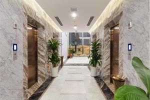 芽庄Emerald Bay Hotel & Spa的楼内带有盆栽的走廊