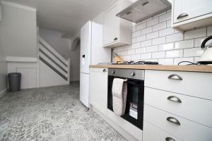 庞蒂浦Wern farm cottage的厨房配有白色橱柜和炉灶。