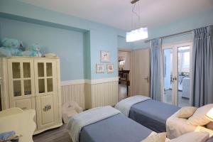 瓦里Vacation house with stunning view - Vari Syros的儿童卧室配有两张床和一张沙发