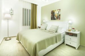 库萨达斯Rodina Suites Hotel的白色卧室配有白色的床和灯