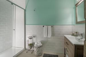 库萨达斯Rodina Suites Hotel的一间带玻璃淋浴和水槽的浴室