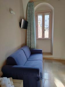 格拉维纳普利亚Le Stanze di Finya的客厅设有蓝色的沙发和窗户。