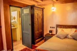 瓦尔扎扎特Ouednoujoum Ecolodge & Spa的一间卧室设有一张床和一个开放式门