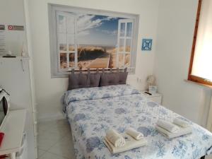 阿祖罗港La Casa di Berenice a Porto Azzurro的一间卧室配有带毛巾的床