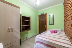 圣保罗HOSTEL HOME ACADEPOL METRO BUTANTA e USP的一间卧室设有一张床和砖墙