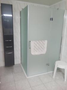 NeuhausGünstig übernachten am Ostseestrand的浴室设有玻璃淋浴间和白色凳子