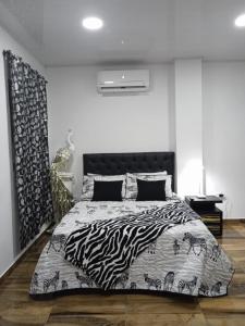 巴耶杜帕尔HOTEL REAL DEL VALLE的一间卧室配有一张带斑马印花床单的床