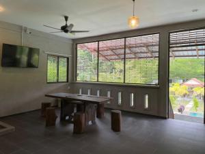 邦咯Pangkor Nature View House的一间带桌子和一些窗户的用餐室