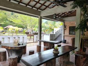 邦咯Pangkor Nature View House的庭院设有两张桌子、凳子和树木