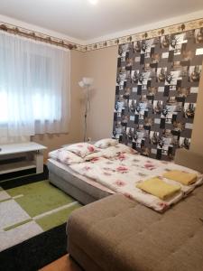 豪伊杜索博斯洛Margit Apartman的一间卧室设有一张大床和一个窗户。