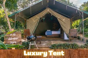 Ponta MalanganeSky Island Resort的一个带床和椅子的帐篷和一个烧烤架