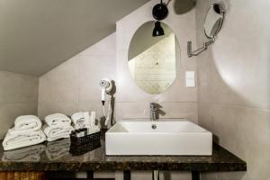 第比利斯Rasta Maidan Hotel的浴室配有盥洗盆、镜子和毛巾