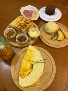 格拉玛多Lala Haus Gramado的餐桌上摆放着早餐食品和华夫饼