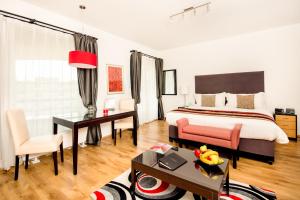 布达佩斯Escala Hotel & Suites的一间卧室配有一张特大号床、一张桌子和椅子