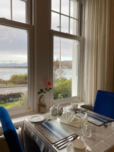 奥本阿兹住宿加早餐旅馆的一张带蓝色椅子的桌子和一张带两个窗户的桌子