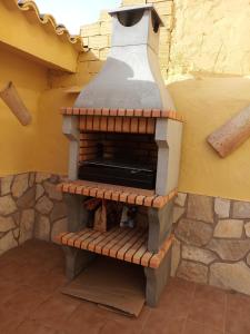 FuentealbillaCasa Rural Tia Catalina的砖炉,坐在墙上