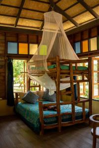 考索Monkey Mansion - Jungalows & Tours的一间卧室配有一张带蚊帐的木床