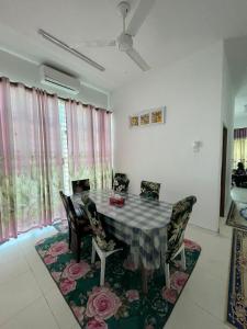 双溪大年Basic Homestay For Big Family With Wifi 100mpbs的一间位于地毯上的带桌椅的用餐室