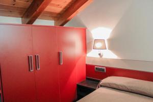 Alins萨罗利亚酒店的红色卧室设有一张床和一个红色橱柜