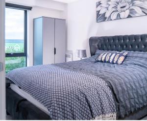 BroadheathManchester lovely two bedrooms apartment的一间卧室配有一张带蓝色床罩的床和窗户。